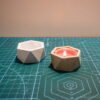 Concrete and Paper Geometric Candlesticks on a green background front view