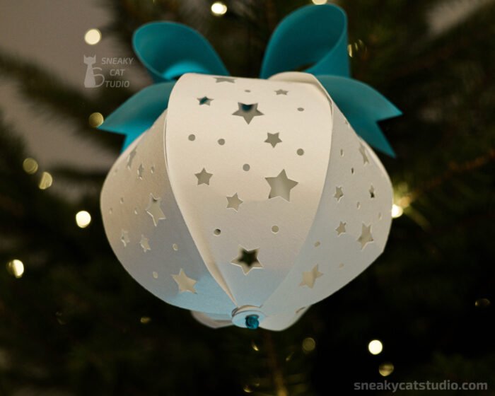 White paper Christmas ball with star pattern on the Christmas tree with light bottom view