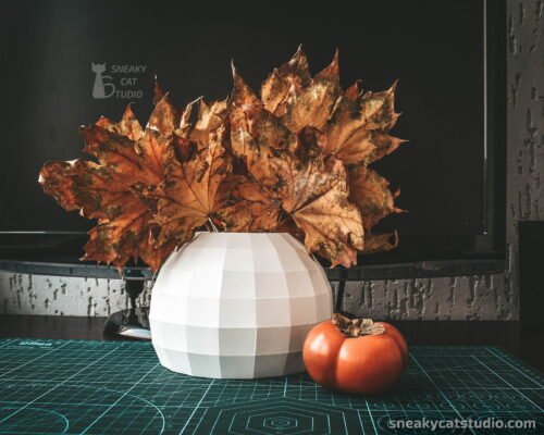 Geometric vase for interior with autumn leaves and persimmon on a green background main view