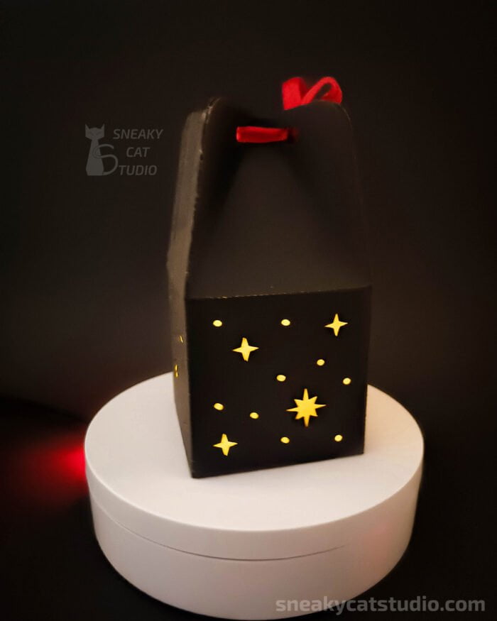 Paper black box with stars pattern on dark background back view