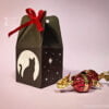 Paper black box with cat, moon and stars pattern with sweets on pink background front view