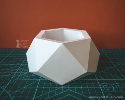Geometric paper planter on a green background front view