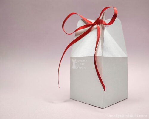 Simple white box with red ribbon on a pink background
